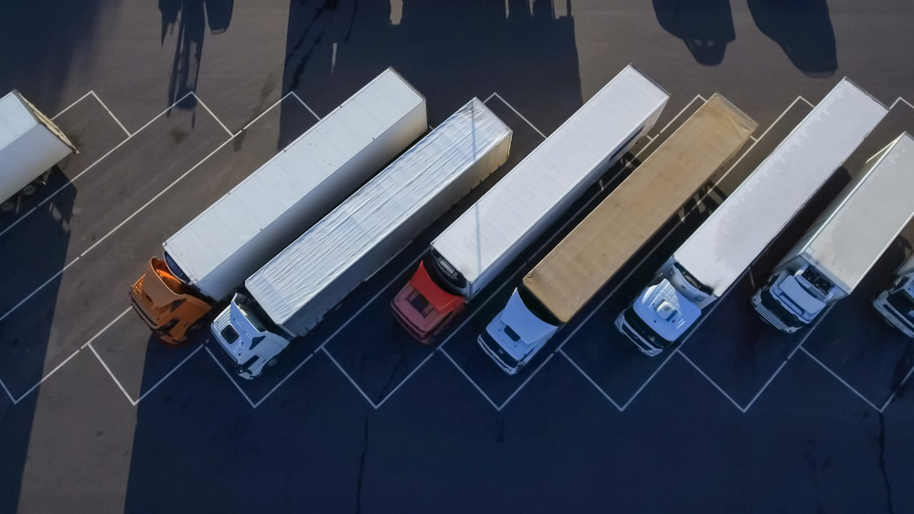 Widok z góry z lotu ptaka białych naczep na parkingu dla ciężarówek GeoNAVI